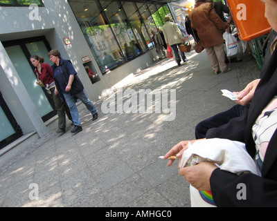 Straßenszene mit einer Zigarette beobachten Passanten in Berlin Deutschland Stockfoto