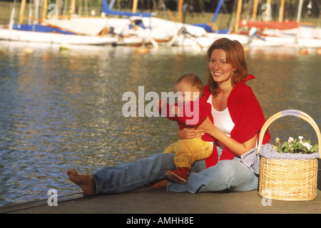 Mutter und Tochter sitzen zusammen am Kanal in Stockholm Schweden Stockfoto