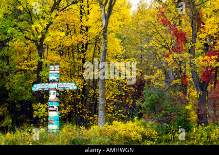 Ein Totempfahl mit Herbst Laub Farbe in St-Vital-Park in Winnipeg, Manitoba Kanada Stockfoto