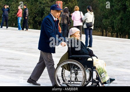 Älterer Mann schob alternden Frau in einem Park in Peking China Stockfoto