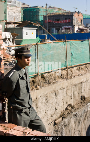 Junge Wachmann steht die Uhr auf dem Gelände der Zerstörung von einem Hutong in Peking Stockfoto