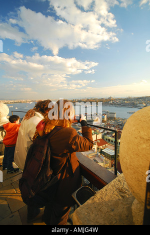 ISTANBUL, TÜRKEI. Eine junge Frau, die die Stadt von oben auf den Galata-Turm im Stadtteil Beyoglu zu fotografieren. 2007. Stockfoto