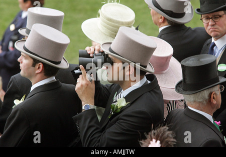 Mann auf der Suche durch ein Fernglas bei Royal Ascot Pferderennen, York, Großbritannien Stockfoto