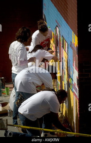 Freiwillige mit New York kümmert sich malen eine Wandbild auf der Seite der PS 33 Chelsea School in New York City Stockfoto