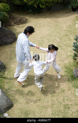 Vater und Kinder spielen im Garten Stockfoto