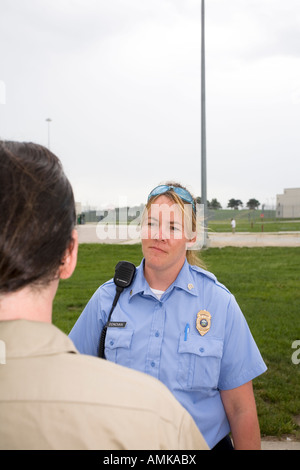 Justizvollzugsanstalt Polizistin im Gespräch mit männlichen Insassen im Hof des Hochsicherheitsgefängnis. Stockfoto