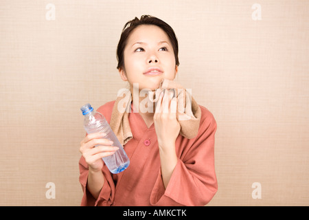 Junge Frau Gesicht mit Tuch abwischen Stockfoto