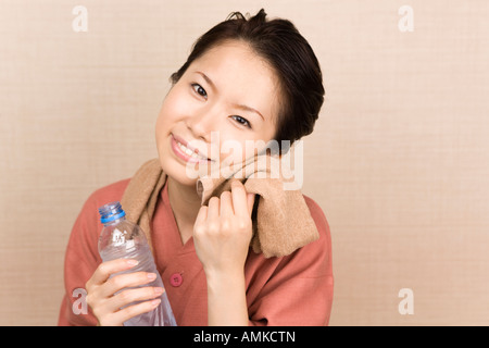 Junge Frau Gesicht mit Tuch abwischen Stockfoto