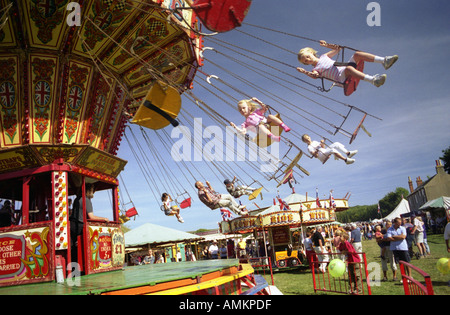 Zwei Mädchen fahren im sitzen auf einem Karussell. Findon Dorf Schafe Messe, West Sussex, England Stockfoto