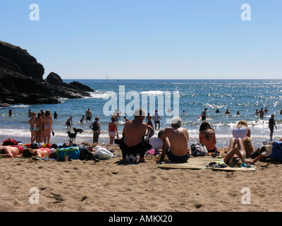 Familien Schwimmen in eine glitzernde Meer und genießen Sie einen Sommerurlaub Wochenende an einem beliebten Strand auf der South Devon Coast. Großbritannien Stockfoto