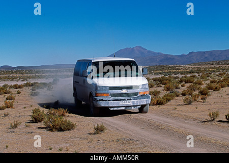 Ein Tourist-Fahrzeug fährt auf einem Schotterweg durch das Altiplano auf dem Weg zum Pisiga Bolivar Grenzposten mit Chile Stockfoto