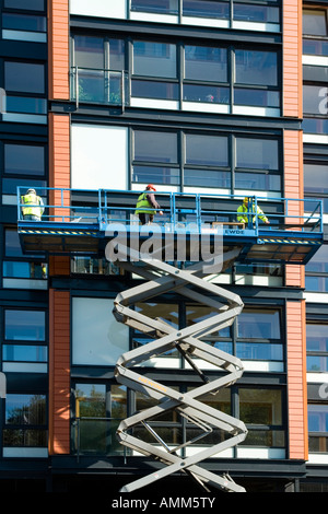 Männer arbeiten auf Wohnungen im ehemaligen Templetons Teppich Fabrik Glasgow Green Schottland Europe Stockfoto