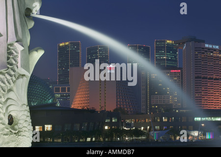 Detail der Merlion Statue in Singapur in der Dämmerung mit dem Marina Square Komplex im Hintergrund. Stockfoto