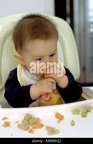 sieben Monate altes Baby Boy selbst mit Löffel füttern Stockfoto