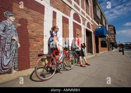 Zwei junge Frauen machen Sie eine Pause vom Radfahren auf Eisenbahn Straße in St. Johnsbury Vermont Stockfoto