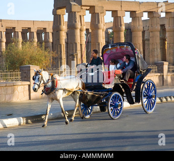 Touristen, Reiten in einer Caleche Pferdekutsche vor den Toren der Tempel von Luxor in Ägypten Stockfoto