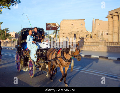 Touristen, Reiten in einer Caleche Pferdekutsche vor den Toren der Tempel von Luxor in Ägypten Stockfoto