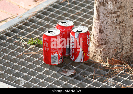Drei entsorgt leere Getränkedosen auf der Etage gegen einen Baum in Palma Nova, Mallorca. Stockfoto