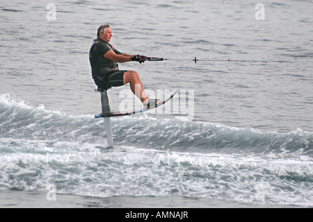 Mann auf Wasserski Stuhl gezogen mit hoher Geschwindigkeit durch Motorboot in Palma Nova. Stockfoto