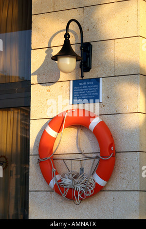 Wand und montierten lebensrettende Ring mit einem Seil an Hotel-Wand im Bereich Schwimmbad ins kalte Wasser zu beleuchten. Stockfoto