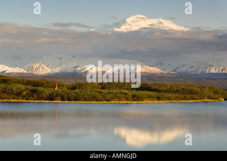 ALASKA DENALI NP Mountainbiker mit Blick auf Reflexion Teich MT McKINLEY durch Wolken im Hintergrund Herr Höchststand Stockfoto