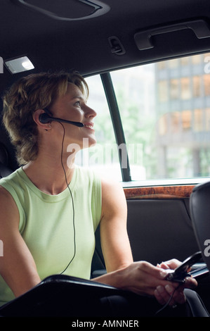Frau mit Handy im Auto Stockfoto
