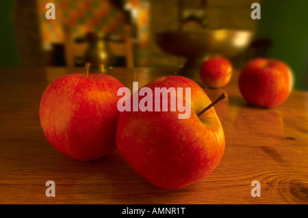 rote Äpfel auf einem Tisch Kiefer in einer Küche Stockfoto