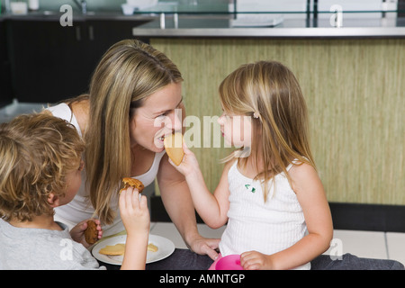 Mutter und Kinder essen Cookies Stockfoto