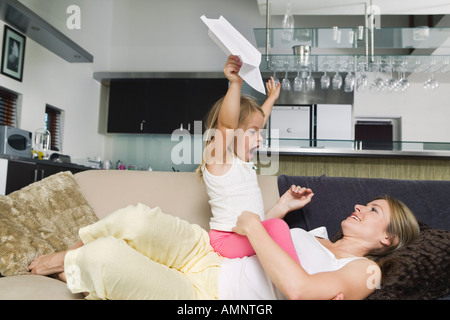 Mutter und Tochter spielen mit Papierflieger Stockfoto