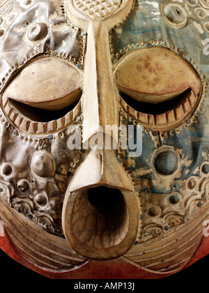 Ethnische traditionelle afrikanische Maske für Stammestänze und Veranstaltungen genutzt. Geschnitzt aus Holz mit geschlagenem Metall-Overlay. Kunst und Handwerk. Stockfoto