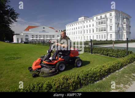 Mann Mähen des Rasens vor dem Kempinski Grand Hotel in Heiligendamm, Deutschland Stockfoto