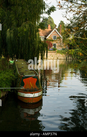 Alte schmale Boot vor Anker in einer ruhigen Rückseite Wasser über das Wehr am Goring und Streatley auf der Themse in Oxfordshire Stockfoto