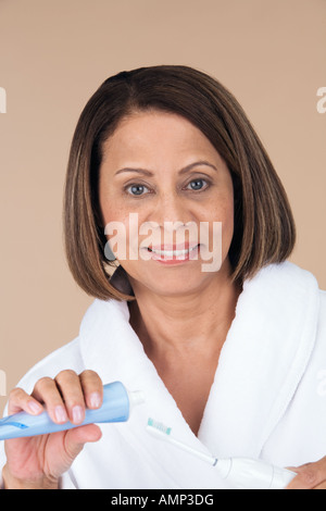 Frau weglegen Zahnpasta auf die Zahnbürste Stockfoto