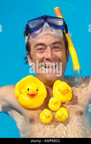 Mann auf seiner Brust mit Gummienten schwimmen Stockfoto