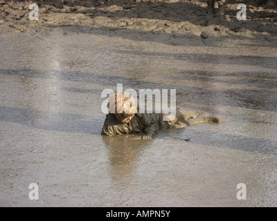 Kleiner Junge im Schlamm liegen in großen Naturteich am Glastonbury 2007 vollständig abgedeckt Stockfoto