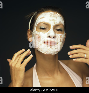 Junge Frau Anwendung Gesichtspackung, close-up Stockfoto