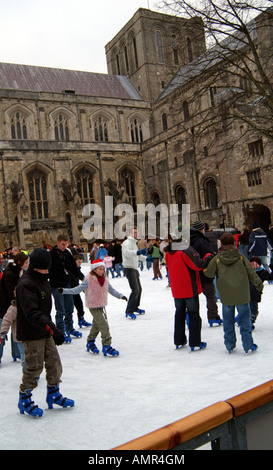 Eisläufer Skating zur Weihnachtszeit auf die temporäre saisonale Eisbahn auf dem Gelände des Winchester Cathedral UK installiert Stockfoto