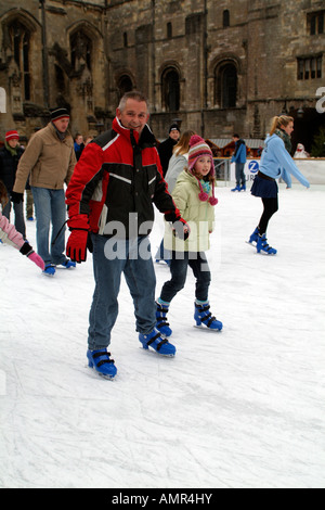 Eisläufer Skating zur Weihnachtszeit auf die temporäre saisonale Eisbahn auf dem Gelände des Winchester Cathedral UK installiert Stockfoto