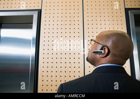 Afrikanische Unternehmer auf der Suche bei elevator Stockfoto