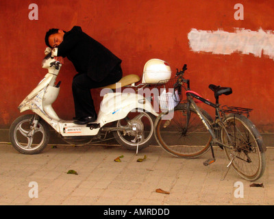 Mann schläft auf Motorroller außerhalb historischen Wuhou Tempel Chengdu Stadt zentral-China Stockfoto