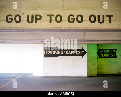 Nach oben um zu gehen - lackiert in schwarz mit einer Schablone auf den Zement-Header eines Parkhauses. Ein großer Pfeil führt zum Ausgang. Stockfoto