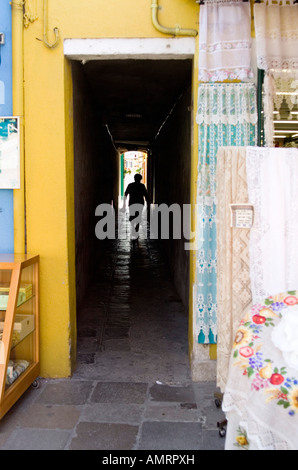 Frau zu Fuß in einer kleinen Gasse in Burano, in der Nähe von Venedig, Italien Stockfoto