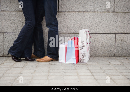 Paar umarmt auf städtischen Straße mit Einkaufstüten Stockfoto