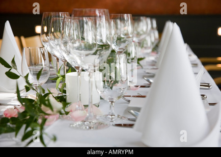 Gedeckter Tisch mit weißen gefalteten Servietten und Weingläser. Stockfoto