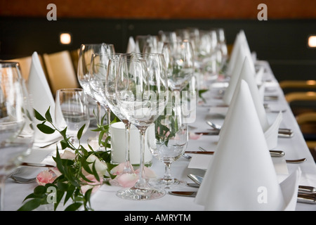 Gedeckter Tisch mit weißen gefalteten Servietten und Weingläser. Stockfoto