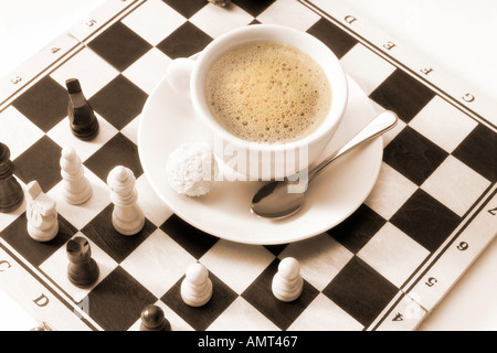 Tasse Kaffee auf Schachbrett Stockfoto