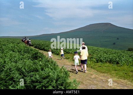 Familie zu Fuß in Landschaft auf Fußweg zum Zuckerhut in der Nähe von Abergavenny South Wales UK Pony Trekker in Ferne Stockfoto