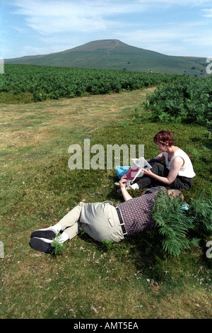 Applying paar Bücher lesen in der Sonne auf Weg zum Zuckerhut in der Nähe von Abergavenny Monmouthshire South Wales UK Stockfoto