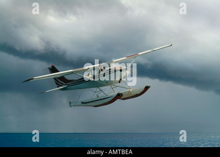 Ein Wasserflugzeug fliegt über das Meer während eines Sturms Gebäude Stockfoto