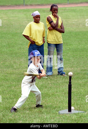 4 und 5 Jahre alten Jungen und Mädchen lernen, wie man einen Ball aus einem Abschlag getroffen Stockfoto